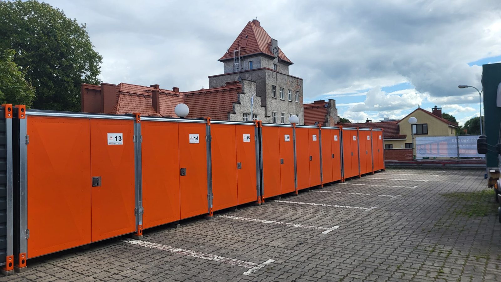 Rząd pomarańczowych boksów magazynowych ELBOX